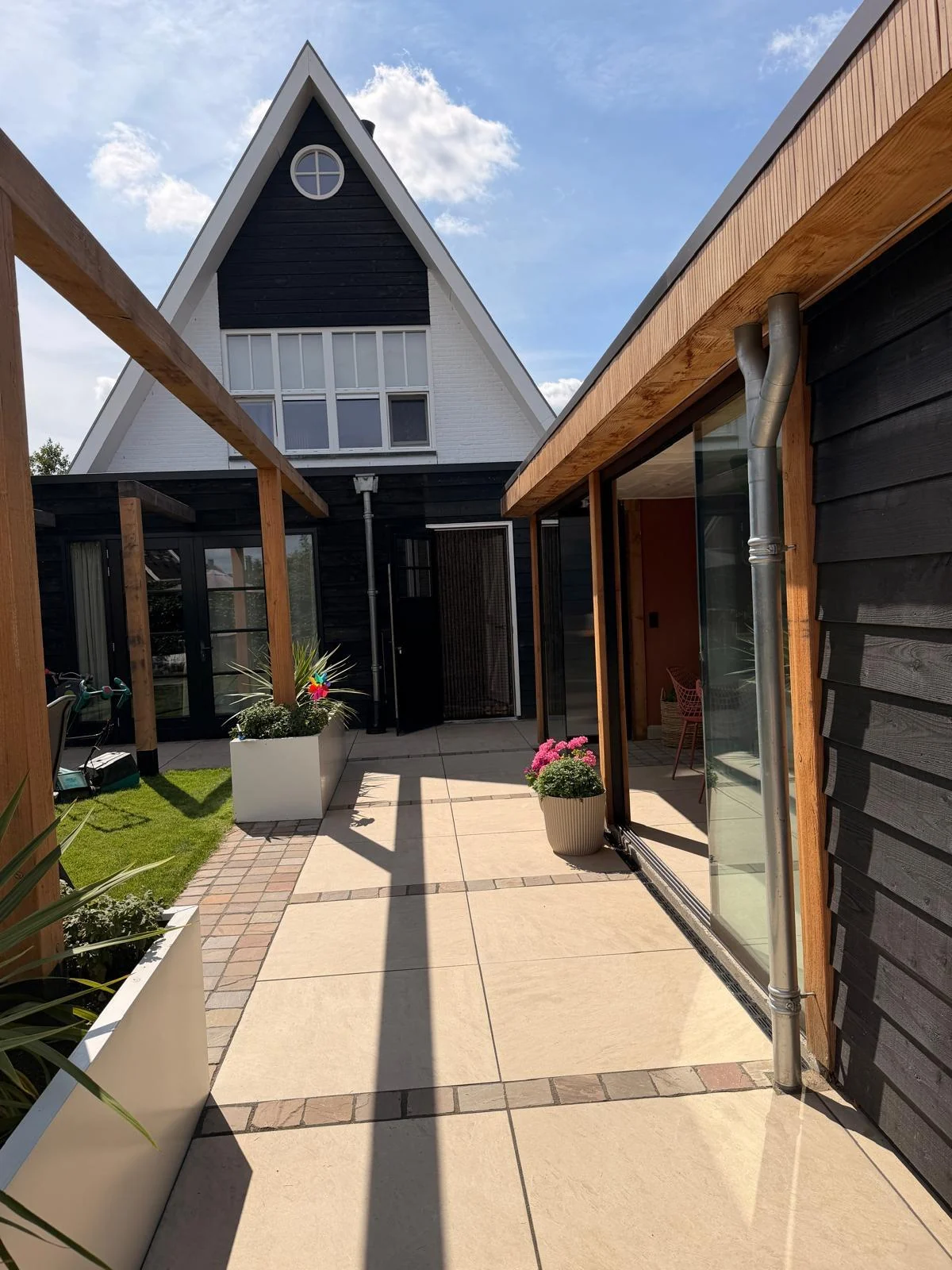 Tegelterras tussen woning en overkapping