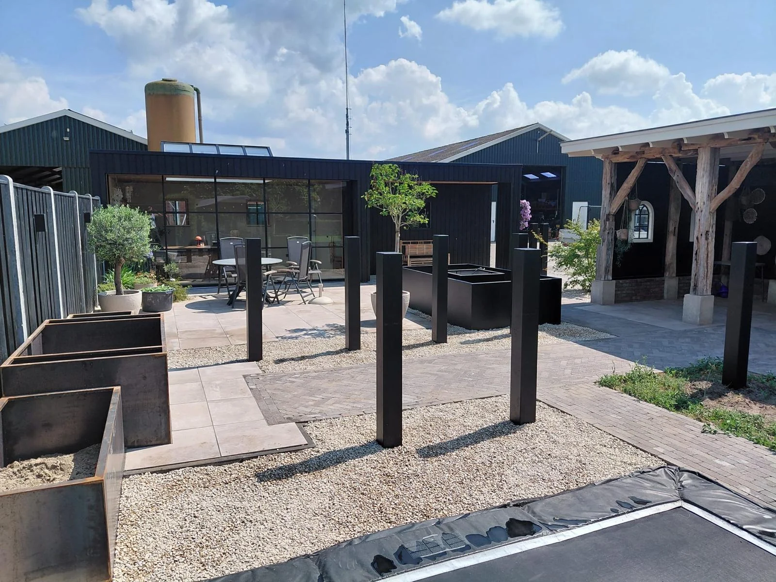 Bestrating, grind en plantenbakken bij de overkapping