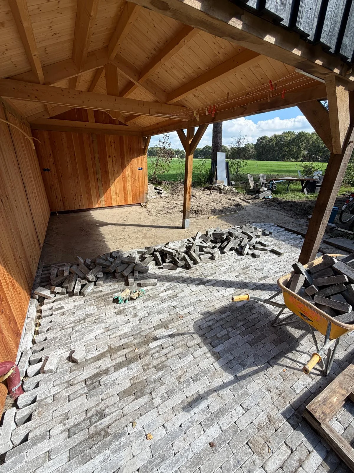Klinkers leggen onder de houten overkapping